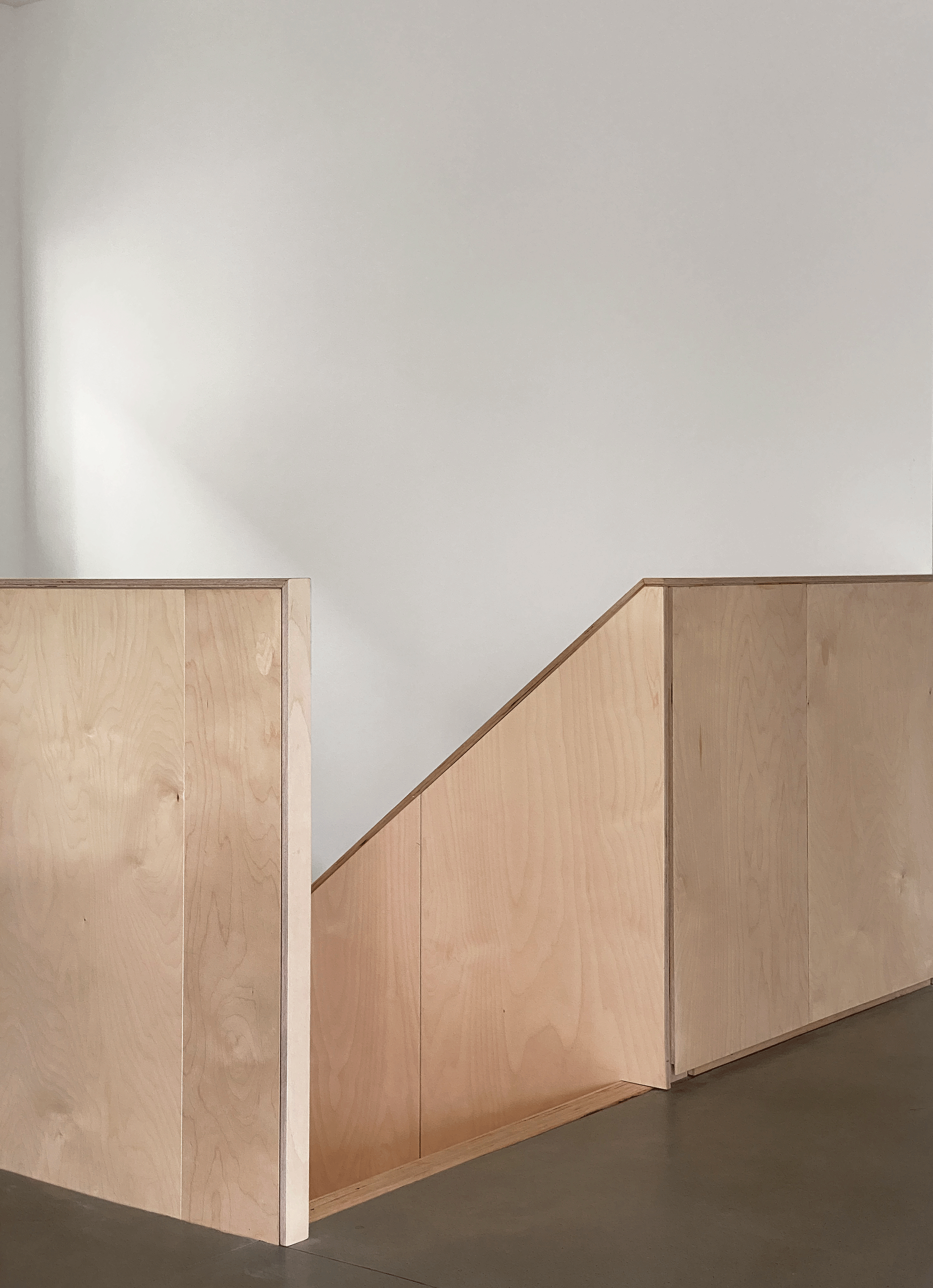 Escalier en bouleau — articulation entre rez-de-chaussée d'usage et étage de vie